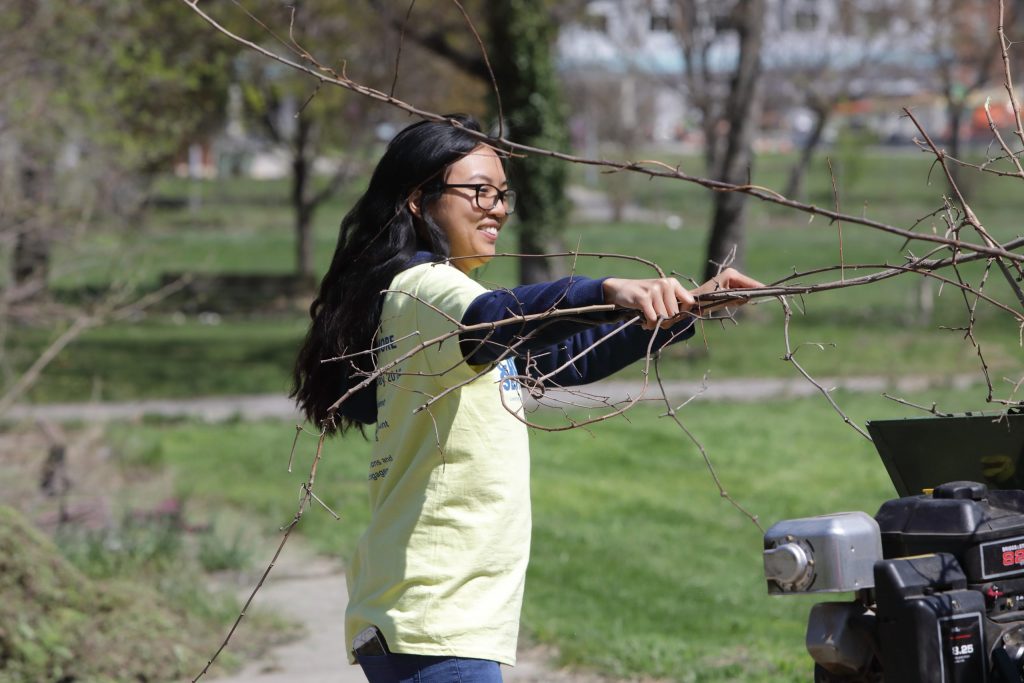 A UBalt student clears branches from a park as part of a service activity