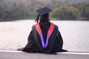 Graduate looks out over a lake