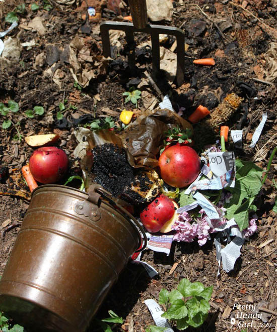 A bucket of kitchen scraps dumped onto the compost pile