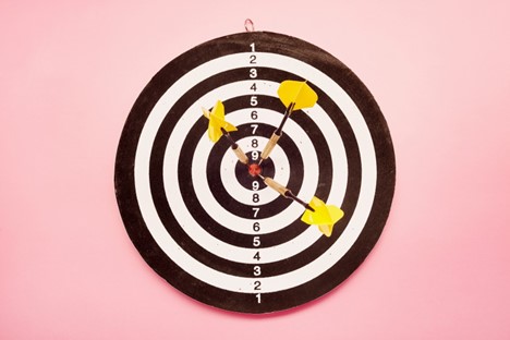 A target with three darts sticking out of the center