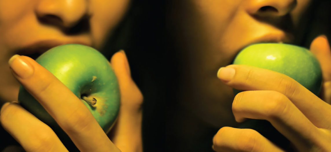 Two people biting into an apple